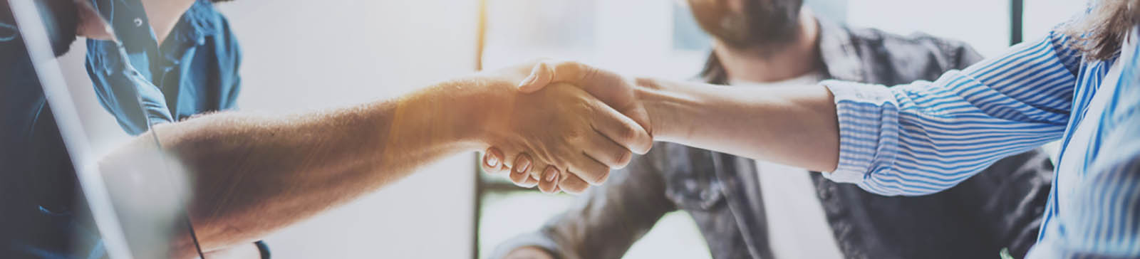 Business partnership handshake concept.Photo two coworkers handshaking process.Successful deal after great meeting.Horizontal, blurred background.Wide.